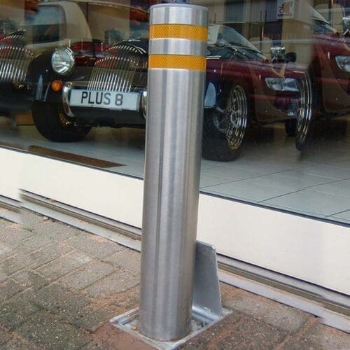 Raised retractable security bollard actively blocking vehicle access for enhanced area protection