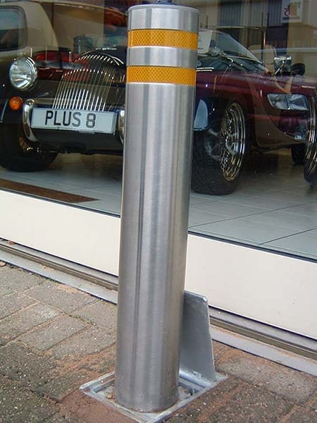 Raised retractable security bollard actively blocking vehicle access for enhanced area protection